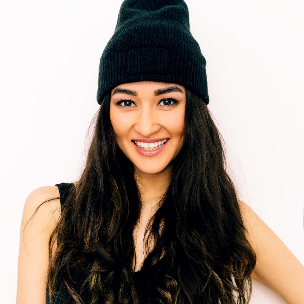 Happy brunette Girl in black clothing and beanie cap. Swag style