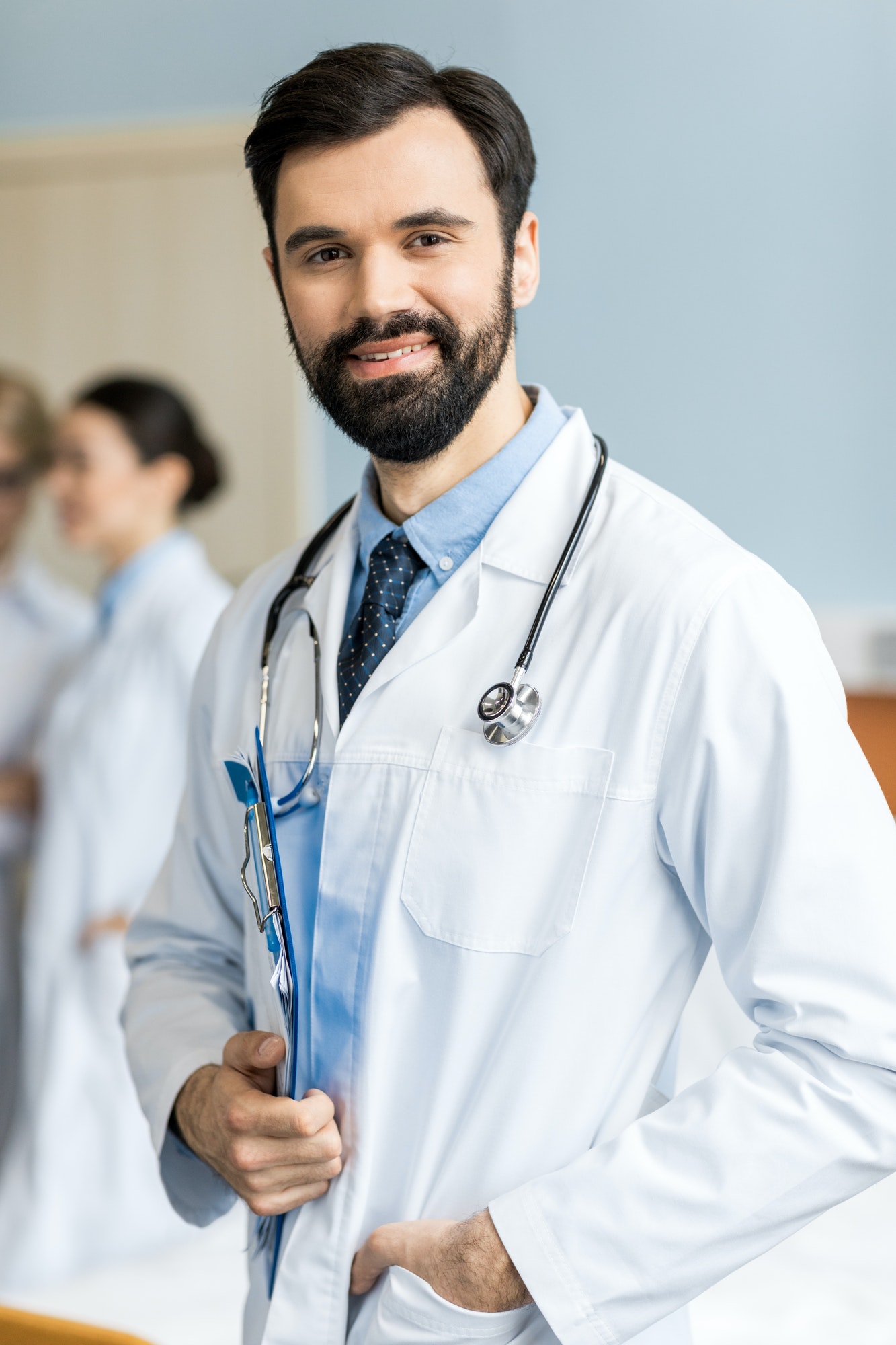 portrait of smiling doctor with doctor stethoscope and folder in clinic